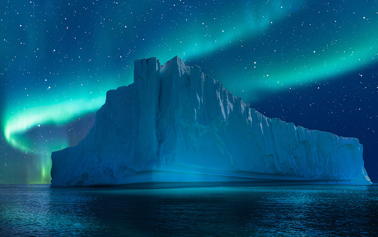 The Northern Lights over a giant iceberg in Greenland